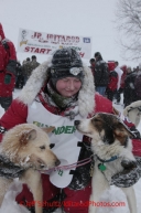 Second place finisher Ben Lyon congratulates his lead dogs at the finish line of the Junior Iditarod on Willow Lake in Willow, Alaska.  Ben came in second just one minute behind first place winner Conway Seavey.