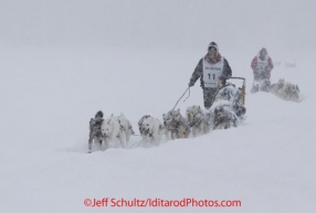 Conway Seavey runs behind his sled, being followed closely by Ben Lyon as the cross Willow Lake in a white-out snow-storm just yards from the finish line.  Conway came in first place, Lyon trailed by just one minute.