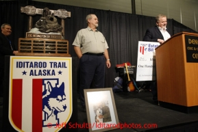 Thursday February 28, 2013  Dale Myers, (L) executor of the estate of the late Bill Devine, original artist of the Iditarod,  presents a $124,000 check to Iditarod Executive Director Stan Hooley to be used to perpetuate the Joe Redington Sr. trophy at the musher drawing banquet held at the Dena'ina Convention Center in Anchorage two days prior to the start of Iditarod 2013.Photo (C) Jeff Schultz/IditarodPhotos.com  Do not reproduce without permission