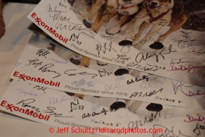 Thursday February 28, 2013   Musher signatures crowd a poster given away by sponsor ExxonMobil at the musher drawing banquet held at the Dena'ina Convention Center in Anchorage two days prior to the start of Iditarod 2013.Photo (C) Jeff Schultz/IditarodPhotos.com  Do not reproduce without permission