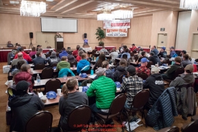 Mushers listen to Race Manager and Marshal Mark Nordman at the mandatory musher meeting at the Lakefront Anchorage hotel in Anchorage, Alaska. Thursday February 28, 2019 Photo by Jeff Schultz/  (C) 2019  ALL RIGHTS RESERVED