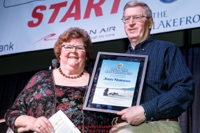 John Norman is presented with the Iditarod Trail Race Foundation Founders Award by Gail Phillips at the pre-race musher drawing banquet at the Dena'ina convention center in Anchorage, Alaska prior to the 2019 Iditarod Trail Sled Dog RacePhoto by Jeff Schultz/  (C) 2019  ALL RIGHTS RESERVED