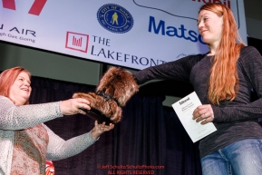 Kristy Berington picks her drawing position from a mukluk at the pre-race musher drawing banquet at the Dena'ina convention center in Anchorage, Alaska prior to the 2019 Iditarod Trail Sled Dog RacePhoto by Jeff Schultz/  (C) 2019  ALL RIGHTS RESERVED