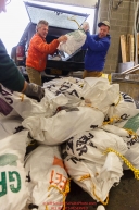 Iditarod musher Linwood Fiedler helps volunteers unload his food drop bags as they sort, weigh, organize and stack the mushers food bags destined for the checkpoints on the 2017 Iditarod at the Airland Transport warehouse facilities in Anchorage Alaska.Wednesday February 15, 2017.Photo by Jeff Schultz/SchultzPhoto.com  (C) 2017  ALL RIGHTS RESVERVED