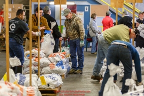 Iditarod volunteers, including John Hooley, unload, weigh, organize and stack the mushers food bags destined for the checkpoints on the 2017 Iditarod at the Airland Transport warehouse facilities in Anchorage Alaska.Wednesday February 15, 2017.Photo by Jeff Schultz/SchultzPhoto.com  (C) 2017  ALL RIGHTS RESVERVED