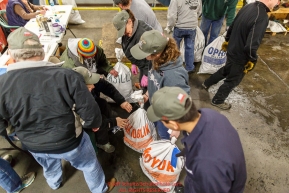 Iditarod volunteers work an assembly line as they unload, weigh, organize and stack the mushers food bags destined for the checkpoints on the 2017 Iditarod at the Airland Transport warehouse facilities in Anchorage Alaska.Wednesday February 15, 2017.Photo by Jeff Schultz/SchultzPhoto.com  (C) 2017  ALL RIGHTS RESVERVED