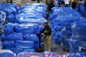 Long-time Iditarod Ed Sundeen stacks some of the 1500 bales of straw at Airland Transport in Anchorage to be sent out to the 22 checkpoints along the Iditarod trail Thursday, Feb. 7, 2013.