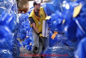 Wyatt Hickman of Black Foot, Idaho plastic wraps some of 1500 bales of straw at Airland Transport in Anchorage to be sent out to the 22 checkpoints along the Iditarod trail Thursday, Feb. 7, 2013. Hickman is volunteering through the Helping Hands ministry, part of the LDS church.