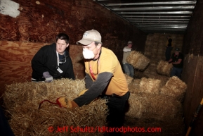 Elder Cottrell, left, and Richard McMahon unload bales of straw to be bagged, palletized and mailed at Airland Transport in Anchorage for the 22 checkpoints along the Iditarod trail Thursday, Feb. 7, 2013.