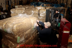 A volunteer since 1986, Larry Cheeso writes the weight of a pallet of hay at Airland Transport in Anchorage to be sent to the Rainy checkpoint along the Iditarod trail Thursday, Feb. 7, 2013.