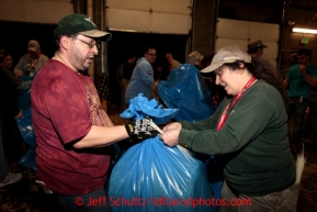 Chris Blankenship, left, and Denise Ronek zip-tie one of the 1500 bags of straw at Airland Transport in Anchorage to be sent out to the 22 checkpoints along the Iditarod trail Thursday, Feb. 7, 2013.