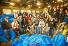 Iditarod volunteers pose for a group photo during the straw bagging day where they unload, bag, stack and shrinkwrap the 1635 bales of straw that is destined for all the checkpoints on the 2017 Iditarod at the Airland Transport warehouse facilities in Anchorage Alaska. Thursday February 9, 2017.Photo by Jeff Schultz/SchultzPhoto.com  (C) 2017  ALL RIGHTS RESVERVED