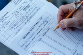 A veterinarian fills out paperwork on a dog at the 2016 Iditarod Pre-race vet check in Wasilla, Alaska. March 02, 2016 Â© Jeff Schultz/SchultzPhoto.com ALL RIGHTS RESERVEDDO NOT REPRODUCE WITHOUT PERMISSION