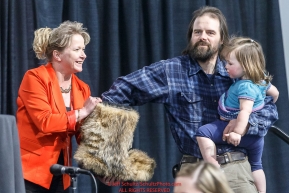 Cim Smyth and his daughter draw his starting position from a mukluk held by Anchorage Chrysler Dodge sponsor Kristine Horst at the 2016 Iditarod musher position drawing banquet at the Dena'ina convention center in Anchorage, Alaska on Thursday March 3, 2016  Â© Jeff Schultz/SchultzPhoto.com ALL RIGHTS RESERVEDDO NOT REPRODUCE WITHOUT PERMISSION