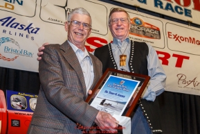 Dr. Terry Adkins (Left), the only veterinarian on the 1973 race receives the Joe Redington Sr. Founder's Award from John Norman at the 2016 Iditarod musher position drawing banquet at the Dena'ina convention center in Anchorage, Alaska on Thursday March 3, 2016  Â© Jeff Schultz/SchultzPhoto.com ALL RIGHTS RESERVEDDO NOT REPRODUCE WITHOUT PERMISSION