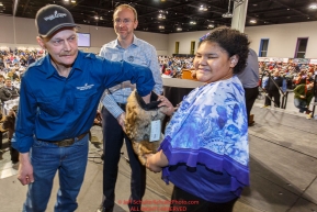 Mitch Seavey draws his position number at the 2016 Iditarod musher position drawing banquet while ExxonMobil sponsor Jamie Long and Make a Wish Iditarider Nakyia Bradford hold the mukluk at the Dena'ina convention center in Anchorage, Alaska on Thursday March 3, 2016  Â© Jeff Schultz/SchultzPhoto.com ALL RIGHTS RESERVEDDO NOT REPRODUCE WITHOUT PERMISSION