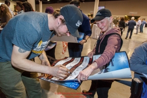 Brent Sass signs a stack of posters for race fans at the 2016 Iditarod musher position drawing banquet at the Dena'ina convention center in Anchorage, Alaska on Thursday March 3, 2016  Â© Jeff Schultz/SchultzPhoto.com ALL RIGHTS RESERVEDDO NOT REPRODUCE WITHOUT PERMISSION