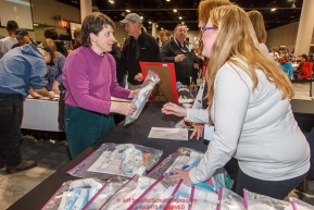 Musher Ellen Halverson, left, receives her dog tags and instructions from volunteers at the 2016 Iditarod musher position drawing banquet at the Dena'ina convention center in Anchorage, Alaska on Thursday March 3, 2016  Â© Jeff Schultz/SchultzPhoto.com ALL RIGHTS RESERVEDDO NOT REPRODUCE WITHOUT PERMISSION