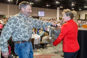 Musher Jim Lanier draws his starting position from a mukluk held by Anchorage Chrysler Dodge sponsor representative Kristine Horst at the 2016 Iditarod musher position drawing banquet at the Dena'ina convention center in Anchorage, Alaska on Thursday March 3, 2016  Â© Jeff Schultz/SchultzPhoto.com ALL RIGHTS RESERVEDDO NOT REPRODUCE WITHOUT PERMISSION