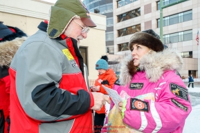 Honorary musher Leo Rasmusson gives a packet of trail mail to DeeDee Jonrowe for her to carry over the trail just prior to the Ceremonial Start of the 2017 Iditarod in Anchorage on Saturday March 4, 2017 Photo by Jeff Schultz/SchultzPhoto.com  (C) 2017  ALL RIGHTS RESVERVED