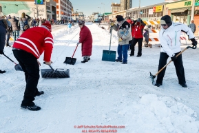 Volunteers shovel snow across the street during the Ceremonial Start in Anchorage on Saturday March 4, 2017 Photo by Jeff Schultz/SchultzPhoto.com  (C) 2017  ALL RIGHTS RESVERVED