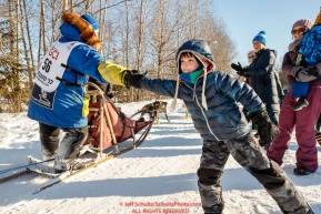 Young Ayden Tuttle gives a high-five to Mellisa Stewart on the bike/ski trail during the Ceremonial Start of the 2017 Iditarod in Anchorage on Saturday March 4, 2017 Photo by Jeff Schultz/SchultzPhoto.com  (C) 2017  ALL RIGHTS RESVERVED