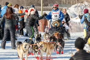 Hugh Neff gets a hot dog handed to him along the bike/ski trail during the Ceremonial Start of the 2017 Iditarod in Anchorage on Saturday March 4, 2017 Photo by Jeff Schultz/SchultzPhoto.com  (C) 2017  ALL RIGHTS RESVERVED
