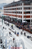 Spectators line the streets of 4th avenue as they watch Noah Pereira run down the trail after leaving the start line during the Ceremonial Start of the 2016 Iditarod in Anchorage, Alaska.  March 05, 2016