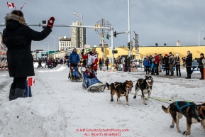 Sigrid Ekran waves to a trail guard on 4th avenue at the Ceremonial Start of the 2016 Iditarod in Anchorage, Alaska.  March 05, 2016