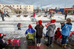 Race fans wave to Travis Beals as he runs down 4th avenue during the Ceremonial Start of the 2016 Iditarod in Anchorage, Alaska.  March 05, 2016