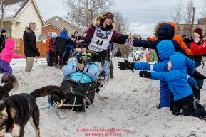 Ryne Olson runs down Cordova Street giving high-fives to spectators during the Ceremonial Start of the 2016 Iditarod in Anchorage, Alaska.  March 05, 2016