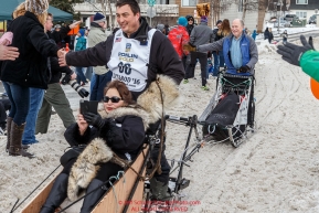 Governor Walker rides the tag-sled of John Baker past spectators on Cordova Street during the Ceremonial Start of the 2016 Iditarod in Anchorage, Alaska.  March 05, 2016