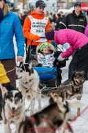 Honorary musher, Joanne Potts in the sled of Jr. Iditarod champion Kevin Harper just prior to leaving the Ceremonial Start of the 2016 Iditarod in Anchorage, Alaska.  March 05, 2016