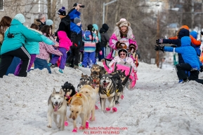 DeeDee Jonrowe runs down Cordova Street giving high-fives to spectators during the Ceremonial Start of the 2016 Iditarod in Anchorage, Alaska.  March 05, 2016