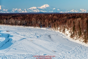 Teams run down the Yentna River with Denali in the background a few hours after leaving the Restart of the 2016 Iditarod in Willow, Alaska.  March 06, 2016.