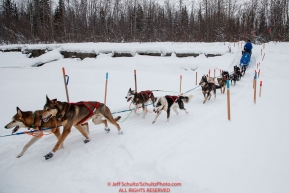 Travis Beals runs down the bank onto the Kuskokwim river 2 miles before arriving at the Nikolai checkpoint during the 2018 Iditarod race on Tuesday afternoon March 06, 2018.  This section of the trail is marked heavily because of overflow on either side of the trail. Photo by Jeff Schultz/SchultzPhoto.com  (C) 2018  ALL RIGHTS RESERVED