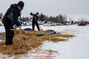 Checkpoint volunteers Marty Day and Erica Goad rake up used straw at the Nikolai checkpoint during the 2018 Iditarod race on Tuesday afternoon March 06, 2018. Photo by Jeff Schultz/SchultzPhoto.com  (C) 2018  ALL RIGHTS RESERVED