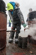 Wade Marrs gets steaming hot water for his dog food at the Nikolai checkpoint during the 2018 Iditarod race on Tuesday March 06, 2018. Photo by Jeff Schultz/SchultzPhoto.com  (C) 2018  ALL RIGHTS RESERVED