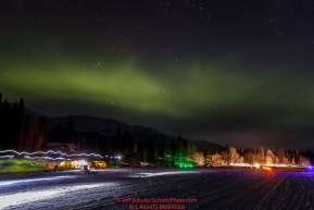 The northern lights light up the sky over resting dog teams in the early morning at the Finger Lake checkpoint at Winterlake Lodge during Iditarod 2016.  Alaska.  March 07, 2016.  Photo by Jeff Schultz (C) 2016 ALL RIGHTS RESERVED