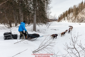 Ray Redington Jr. drops onto the Happy River after coming off the steps between the Finger Lake and Rainy Pass checkpoint during Iditarod 2016.  Alaska.  March 07, 2016.  Photo by Jeff Schultz (C) 2016 ALL RIGHTS RESERVED