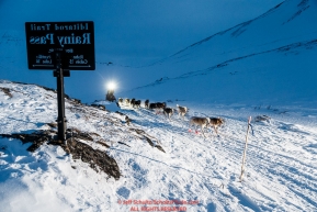 Rick Casillo passes the Rainy Pass summit marker on the trail in the Alaska Range on the way to Rohn from the Rainy Pass checkpoint during Iditarod 2016.  Alaska.  March 07, 2016.  Photo by Jeff Schultz (C) 2016 ALL RIGHTS RESERVED