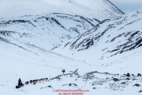 Dallas Seavey crests the summitt of Rainy Pass on the trail in the Alaska Range after leaving the Rainy Pass Checkpoint on the way to Rohn during Iditarod 2016.  Alaska.  March 07, 2016.  Photo by Jeff Schultz (C) 2016 ALL RIGHTS RESERVED