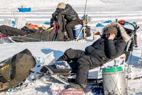 John Baker phones a friend at the checkpoint in Manley Hot Springs as another musher naps on his sled during the 2017 Iditarod on Tuesday March 7, 2017.Photo by Jeff Schultz/SchultzPhoto.com  (C) 2017  ALL RIGHTS RESVERVED