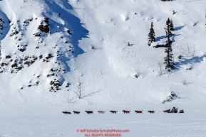 Jeff King sits down on his sled as his team runs next to cliffs on the trail between the Manley and Tanana checkpoings during the 2017 Iditarod on Tuesday March 7, 2017.Photo by Jeff Schultz/SchultzPhoto.com  (C) 2017  ALL RIGHTS RESVERVED