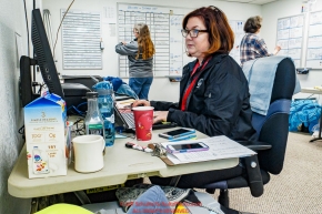 McGrath logistics volunteer Jodie Guest works the computer as swing-pilot Diana Moroney and Deb Miller coordinate loads in the background at the McGrath checkpoint during the 2018 Iditarod race on Wednesday March 07, 2018. Photo by Jeff Schultz/SchultzPhoto.com  (C) 2018  ALL RIGHTS RESERVED