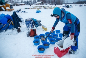 Anja Radano portions her dogs' food into bowls in the morning at the Nikolai checkpoint during the 2018 Iditarod race on Wednesday March 07, 2018. Photo by Jeff Schultz/SchultzPhoto.com  (C) 2018  ALL RIGHTS RESERVED