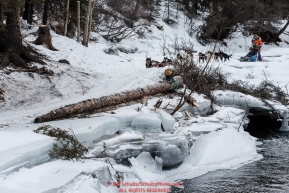 Kim Franklin passes shelf ice and open water on the trail in the Alaska Range in the Dalzell Gorge on the way to Rohn from the Rainy Pass checkpoint during Iditarod 2016.  Alaska.  March 08, 2016.  Photo by Jeff Schultz (C) 2016 ALL RIGHTS RESERVED