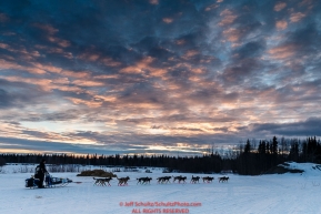 Jason Campeau leaves the Nikolai checkpoint as the sun sets during Iditarod 2016.  Alaska.  March 08, 2016.  Photo by Jeff Schultz (C) 2016 ALL RIGHTS RESERVED