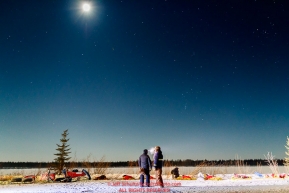 Michelle Phillips works with her dogs on the banks of the Yukon River under a half-moon and stars at Tanana during the 2017 Iditarod on Tuesday March 7, 2017.Photo by Jeff Schultz/SchultzPhoto.com  (C) 2017  ALL RIGHTS RESERVED