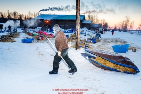 Volunteer John Rothbarth moves a tarp full of straw after raking up after a team at Tanana during the 2017 Iditarod on Wednesday morning March 8, 2017.Photo by Jeff Schultz/SchultzPhoto.com  (C) 2017  ALL RIGHTS RESERVED